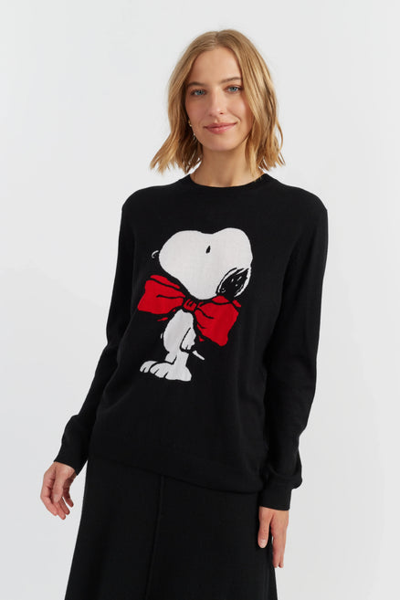 Woman wearing a black sweater with a graphic design on a white background
